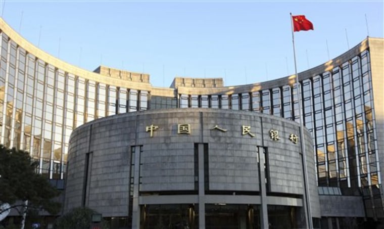 A Chinese flag flutters in front of the headquarters of the People's Bank of China in Beijing. China raised its benchmark lending rate for the first time since emerging from the global crisis.